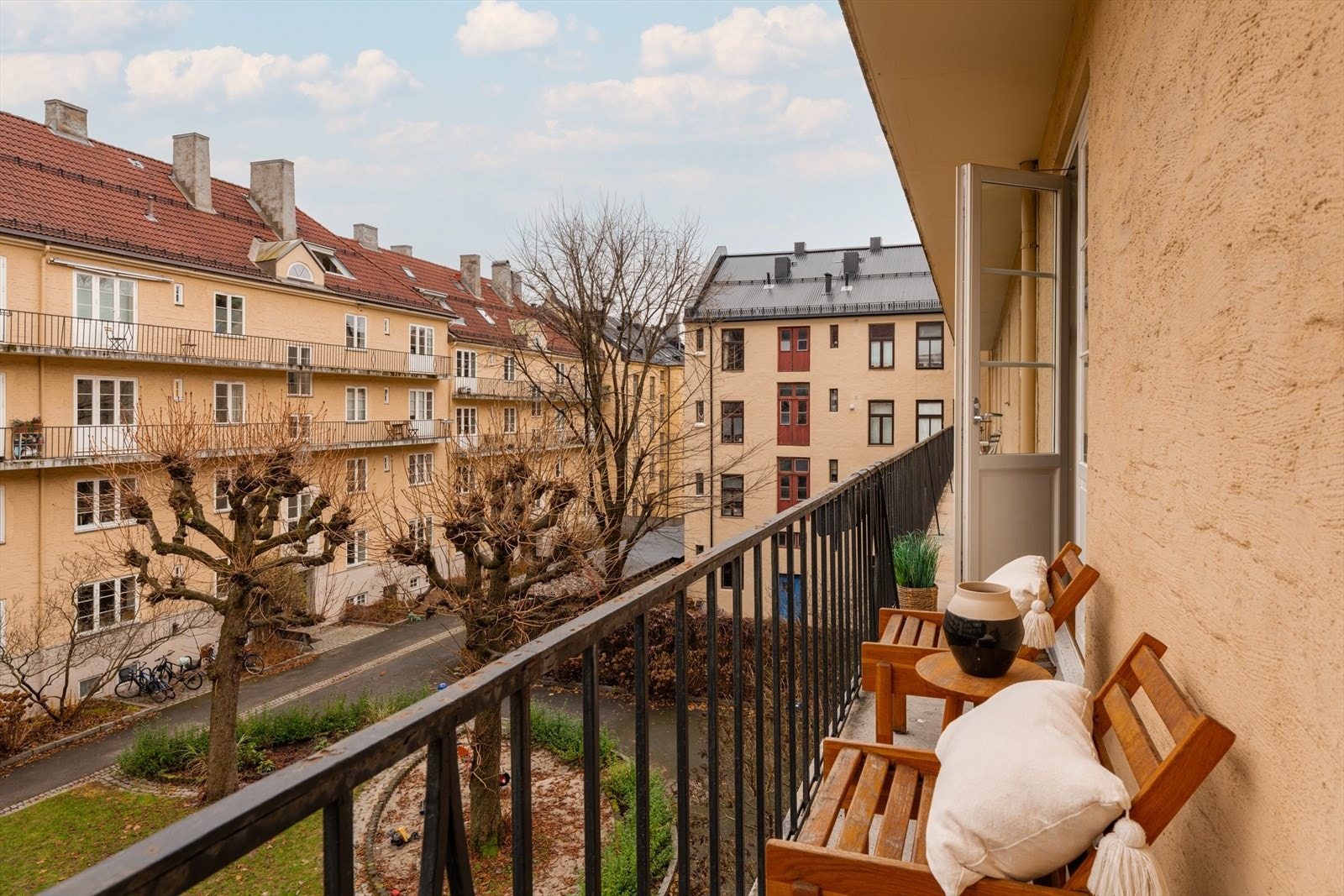 Fin brannbalkong ut mot rolig og lukket gårdsrom. Galleribilde