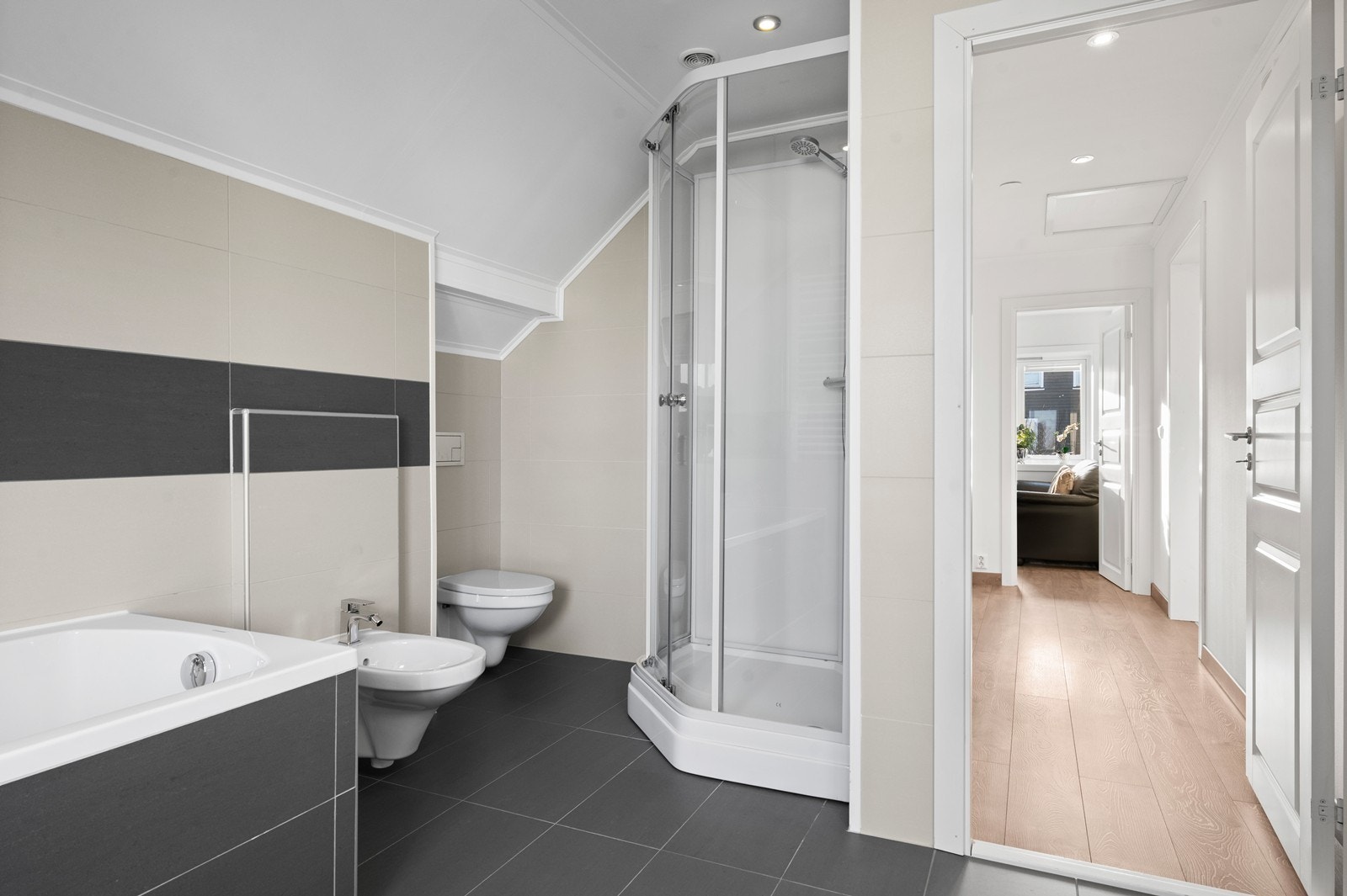 I tillegg til badekar har badet dusjkabinett, vegghengt toalett og bidet. Galleribilde