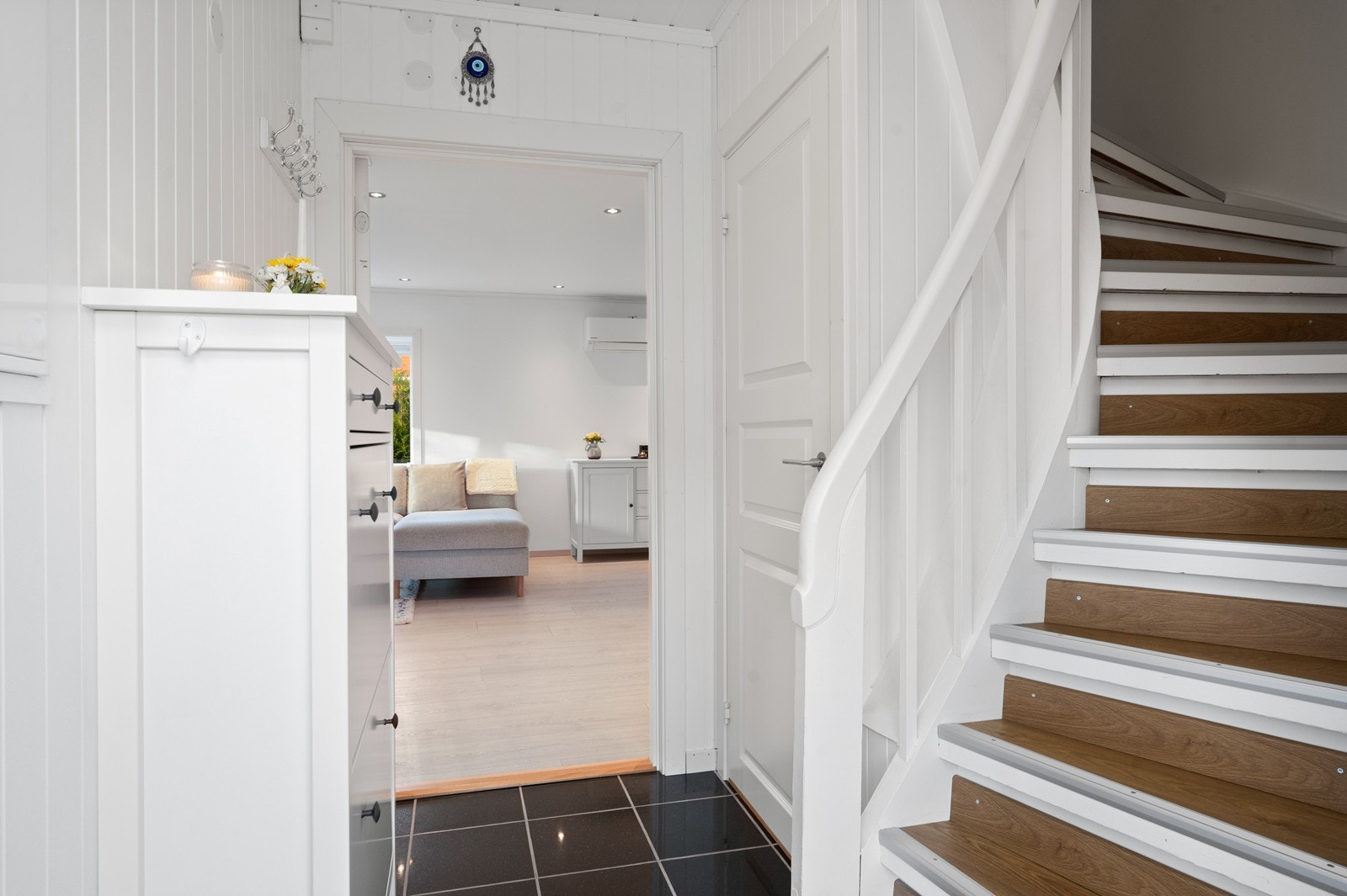 Inngangspartiet har flislagt gulv og trappeforbindelse til boligens øvrige etasjer. Galleribilde