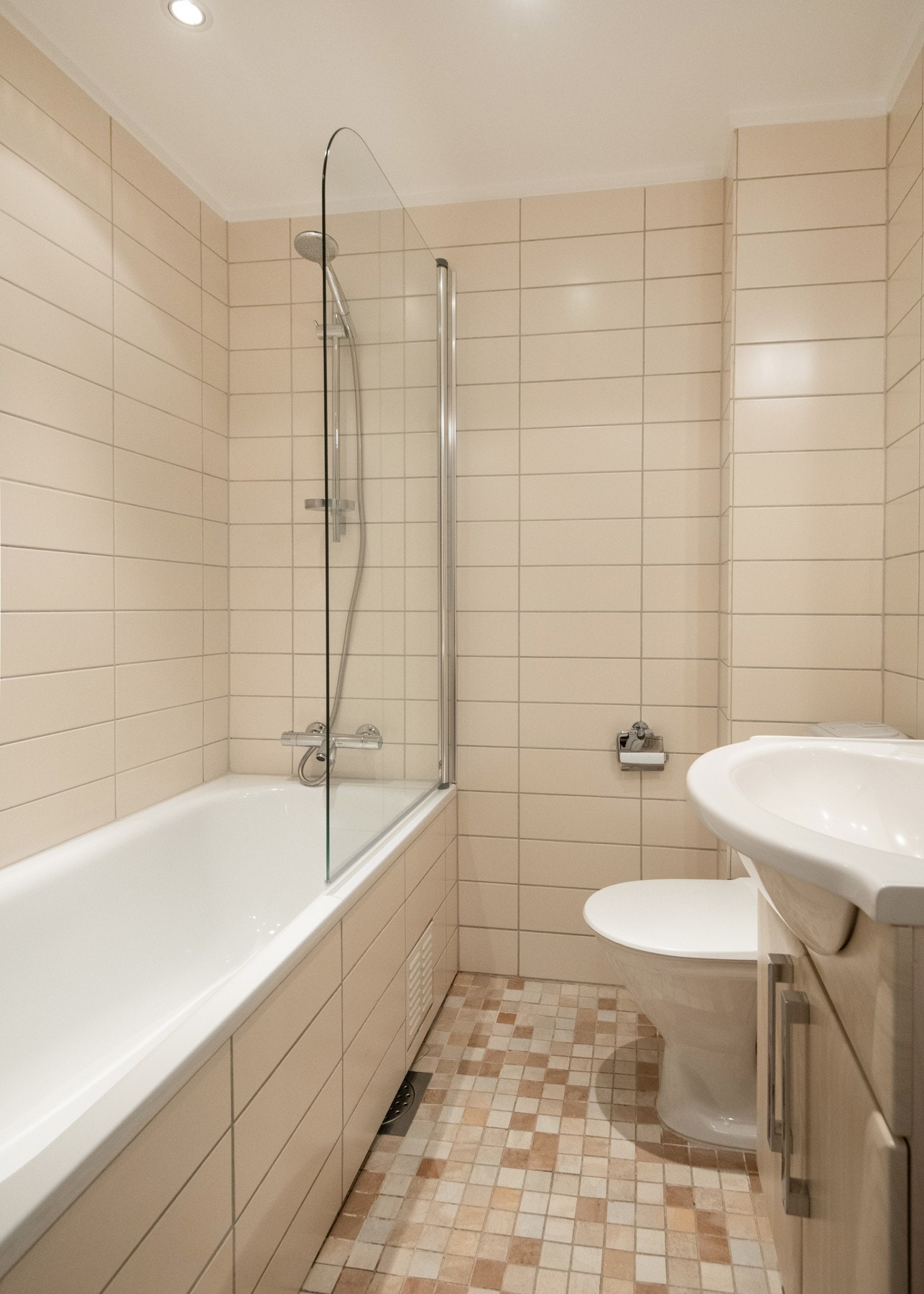 Badet er utstyrt med badekar med vegghengt armatur og dusjløsning med glassvegg, samt et toalett. Galleribilde