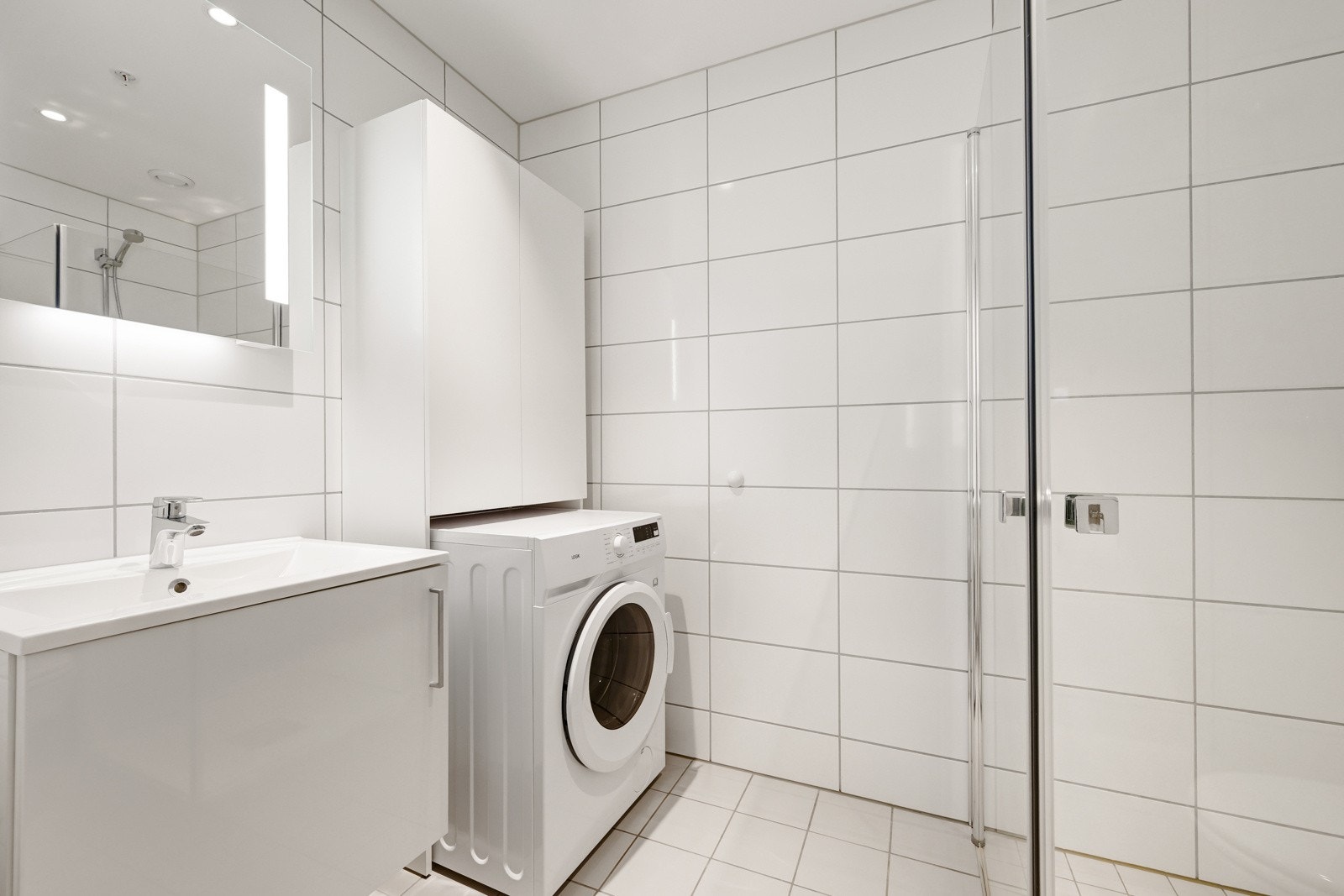 Lyst og lekkert bad med opplegg til vaskemaskin Galleribilde