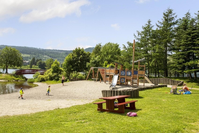 Ta med barn eller barnebarn til elveparken med lekeplass, volleyballbane og sandstrand. Galleribilde