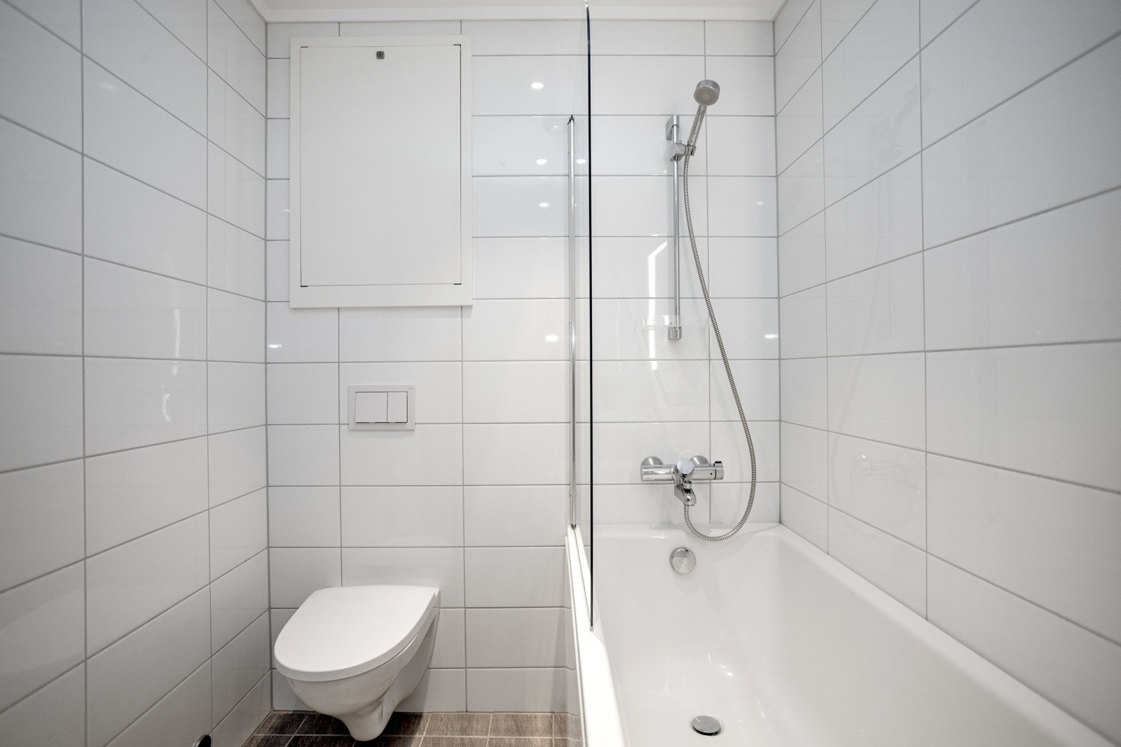 Baderommet inneholder: servant med speil, badekar m/dusj, veggmontert wc, og opplegg for vaskemaskin/tørketrommel. Galleribilde