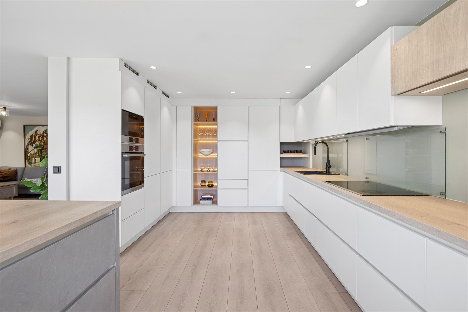 Kjøkkenet er både stilfullt og praktisk innredet med integrert oppvaskmaskin i ståhøyde ved siden av hyllene med lys. Galleribilde