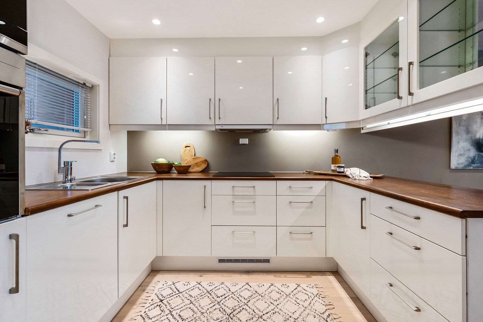 Kjøkkenet har godt med lys, godt med skaper over og under benken. Noen av skapene har sotet glassfronter. Galleribilde