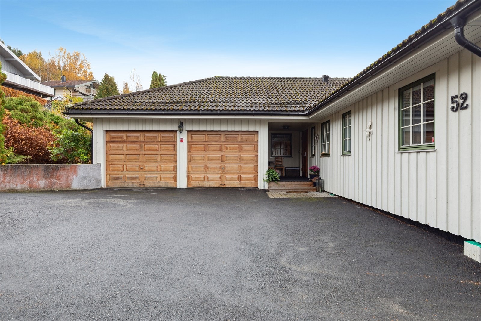 Asfaltert gårdsplass og dobbelgarasje. Galleribilde