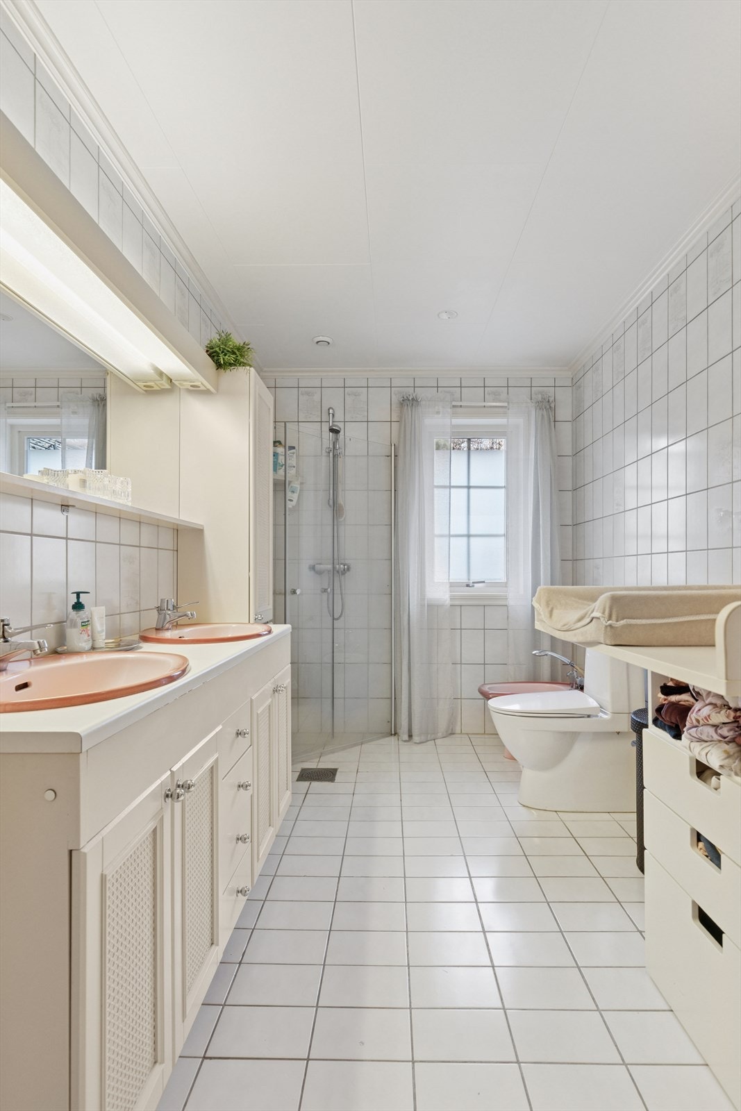 Stort bad i hoveddelen med flislagte overflater og varmekabler. Innredning med dobbel servant og god skapplass. Galleribilde