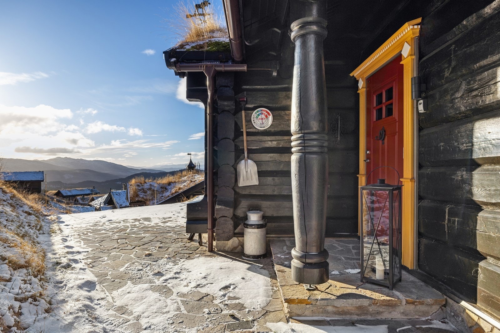 Velkommen inn! Her møtes du av et innbydende inngangsparti med solid, malt entredør og flotte detaljer i laftet tømmer - en stilfull og gjennomført velkomst som setter tonen for resten av hytta. Galleribilde