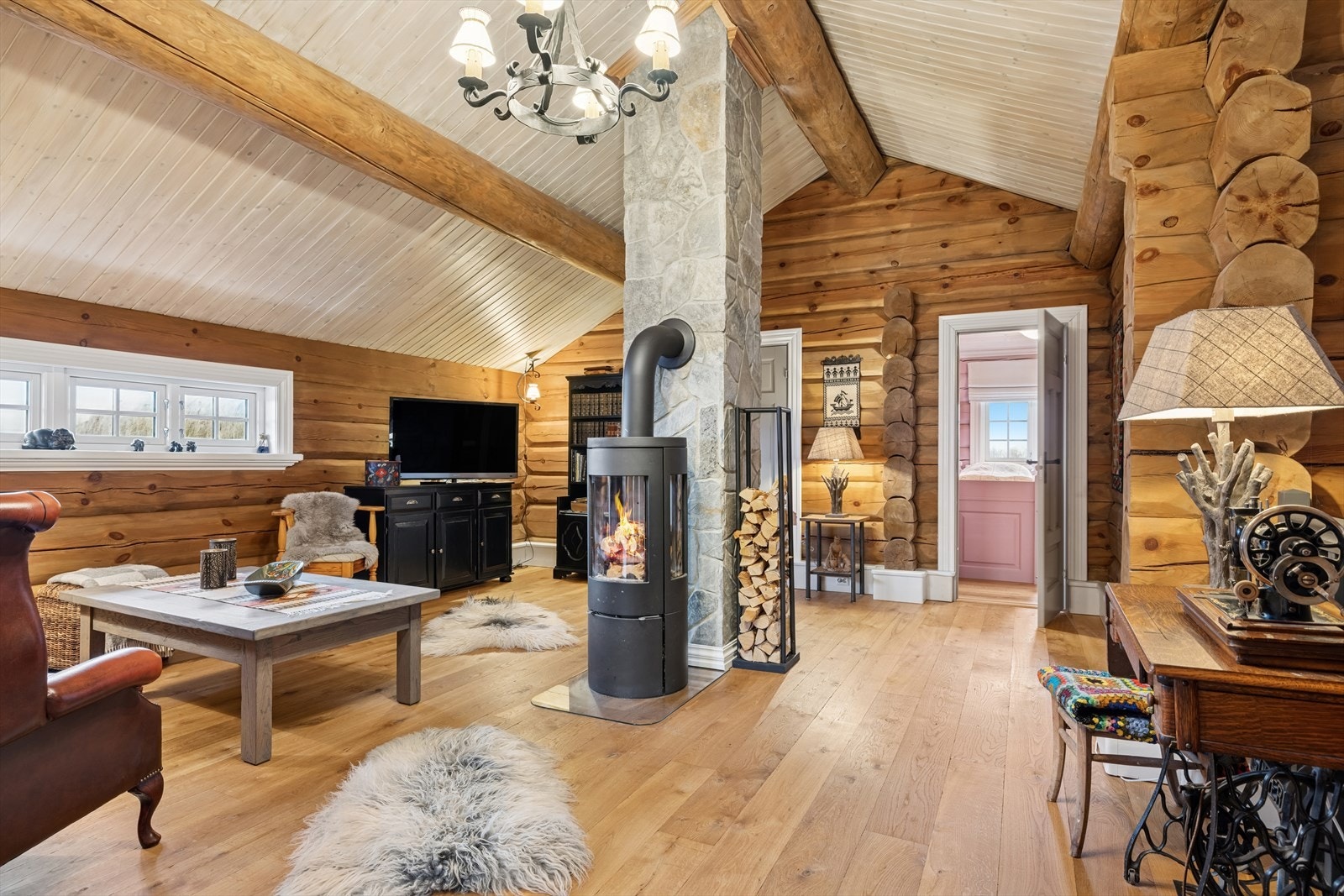 Lofstuen har god takhøyde, flott peis og rikelig plass til møblering - her kan både store og små slappe av og nyte hyggelige stunder sammen. Perfekt for avslapning, lek og sosiale aktiviteter i lyse og luftige omgivelser. Galleribilde