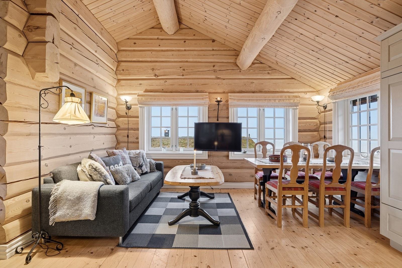 Romslig stue gir deg fleksible møbleringsmuligheter og plass til stor spisegruppe - alt badet i naturlig lys og med panoramautsikt over fjellandskapet. Galleribilde