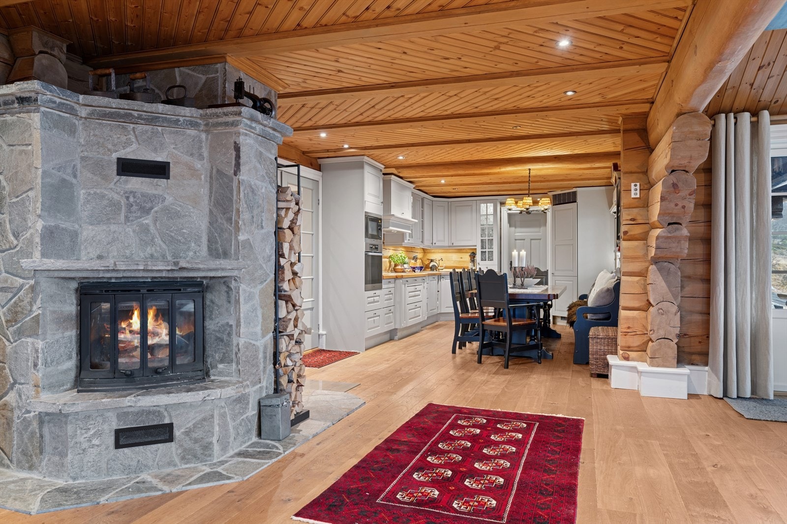 Opplev ekte hyttestemning med en stor, innbydende peis vendt mot den lyse og romslige stuen. Her får du både varme og visuell eleganse - peisen er solid bygget med innsats til pipe i murt lettklinker. Galleribilde