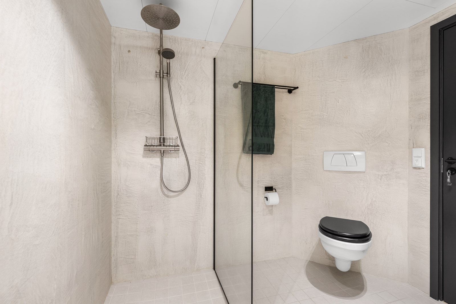 Badet er utstyrt med servant med underskap, speil med skap, dusjnisje med regndusj og glassvegg samt toalett Galleribilde