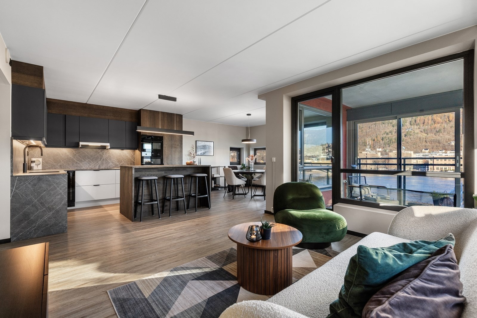 Stue og kjøkken er i en åpen løsning som bidrar til et sosial og hyggelig oppholdsrom Galleribilde