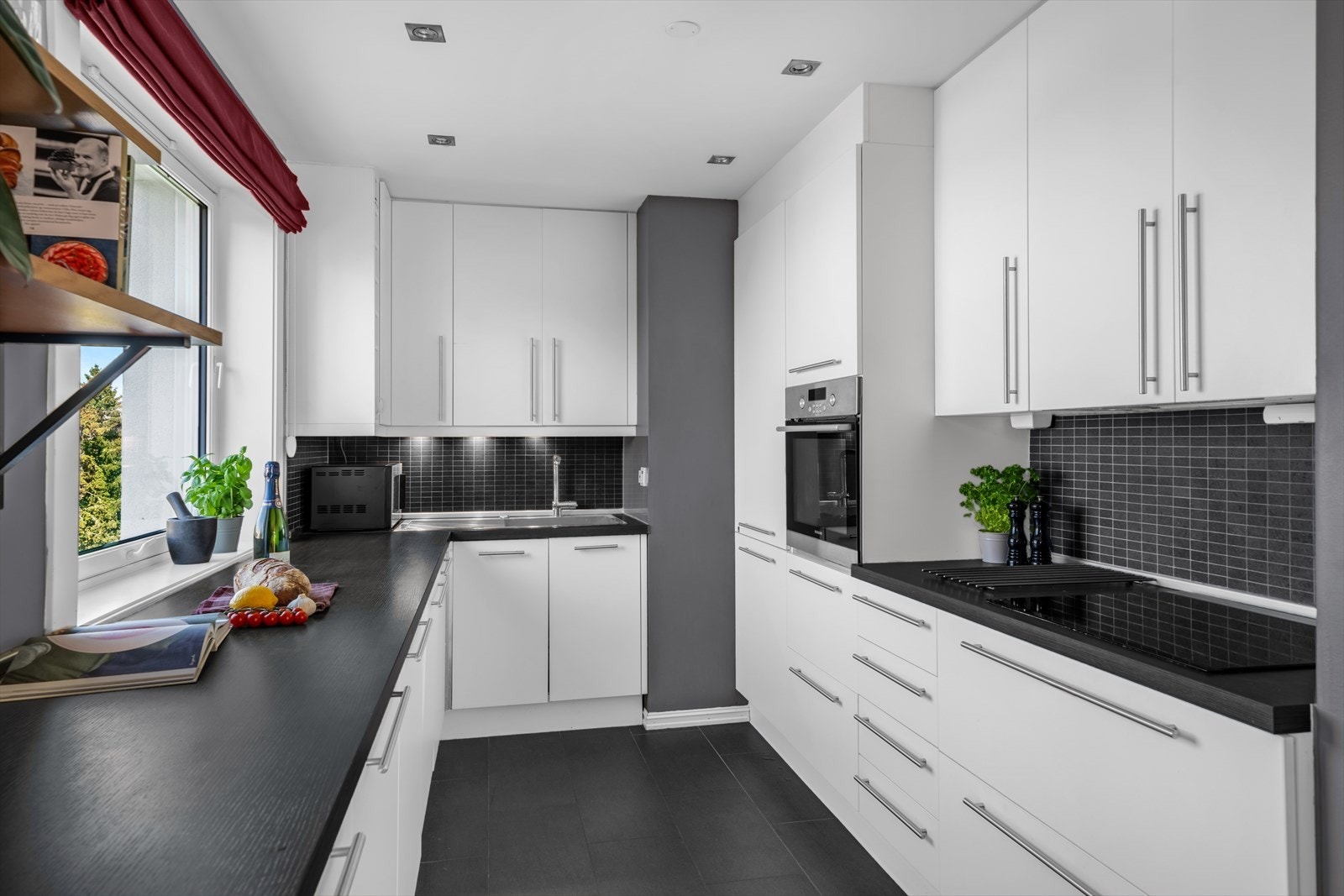 Innredningen har glatte, folierte fronter og en laminatbenkeplate med nedfelt kum i rustfritt stål. Galleribilde