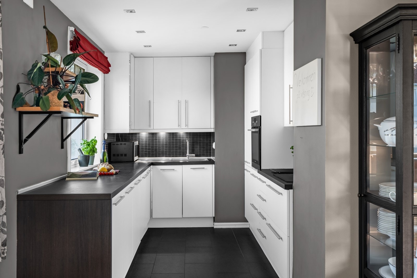 Det er fliser på veggen over benkeplaten og flislagt gulv med gulvvarme. Galleribilde