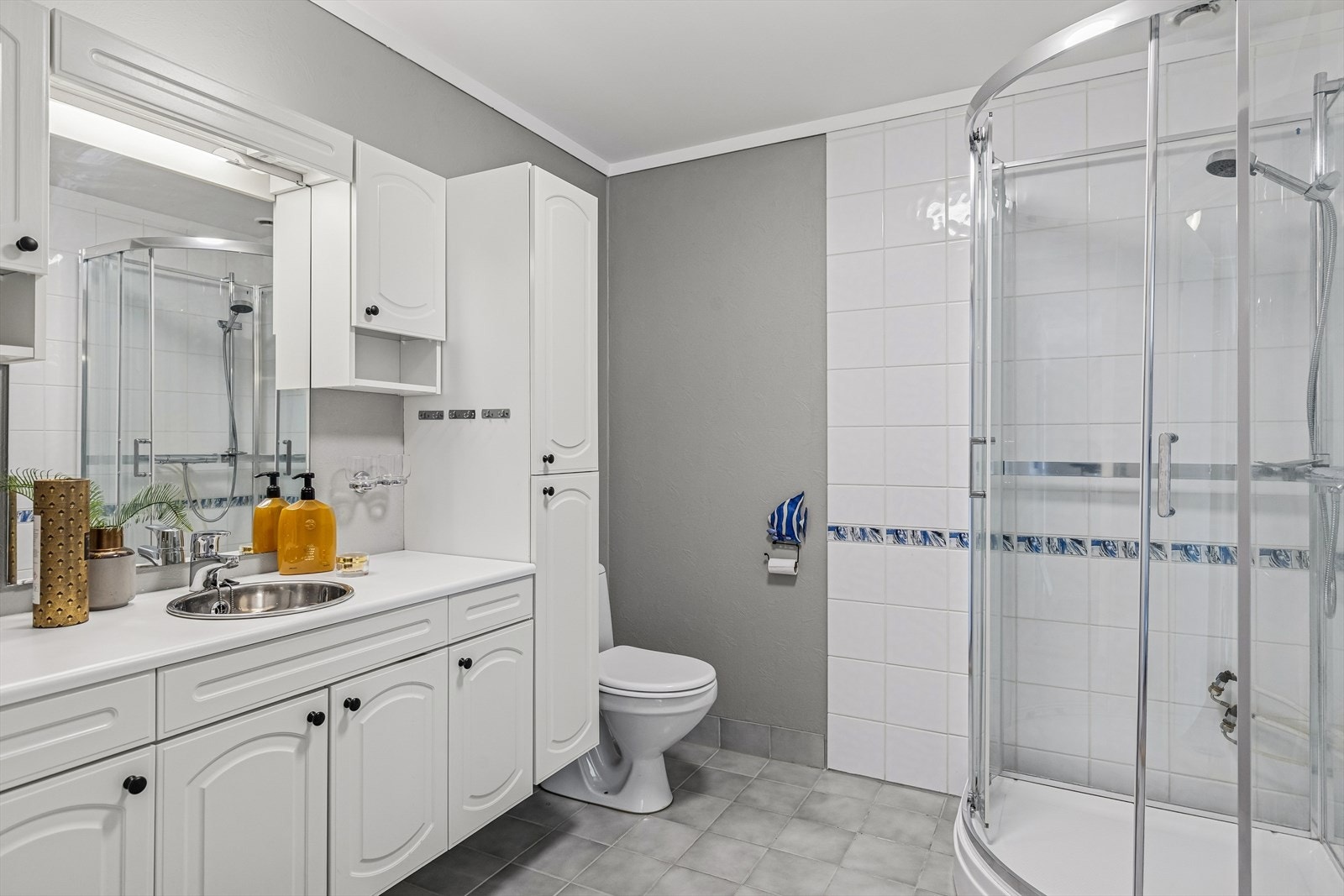 Det romslige baderommet er utstyrt med toalett, dusjkabinett og opplegg for vaskemaskin. Galleribilde