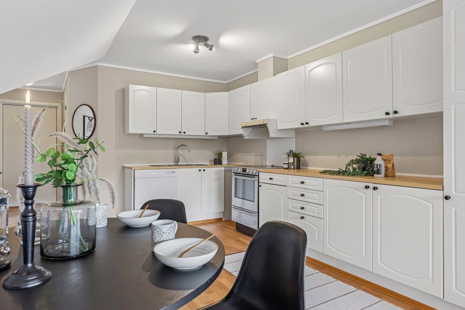 Kjøkkenet er praktisk utformet med god skap- og benkeplass. Innredningen har malte, profilerte fronter og en benkeplate i laminat. Galleribilde