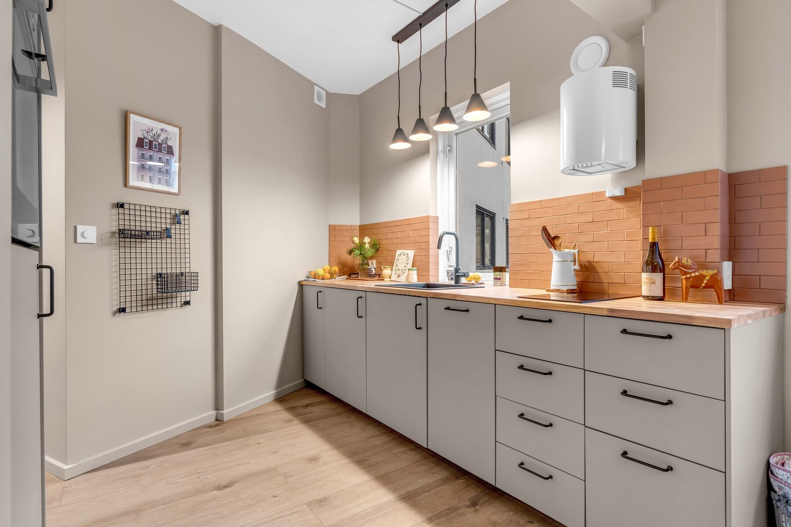 Nedfelt kompositt oppvaskkum og fliser på veggen over kjøkkenbenken. Galleribilde