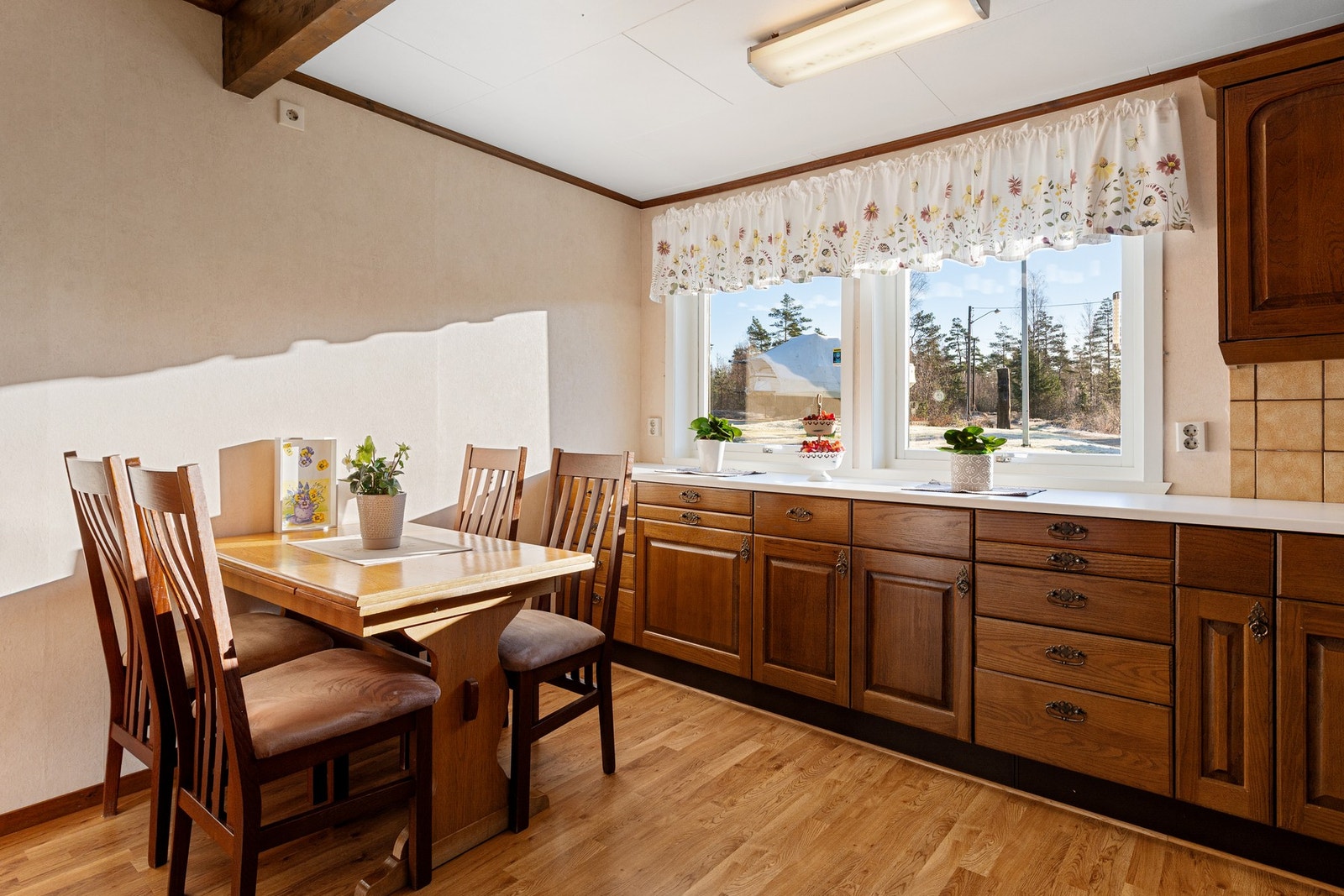 God plass til et hyggelig spisebord ved kjøkkenvinduet. Galleribilde