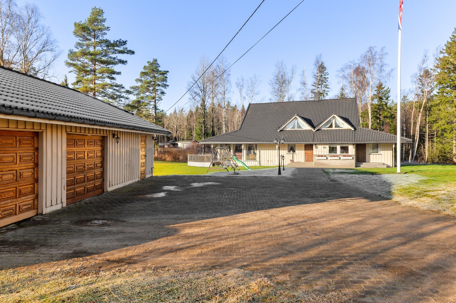 Det er belegningsstein på gårdsplassen ved garasjen, og steinlagt gangvei til huset. Galleribilde