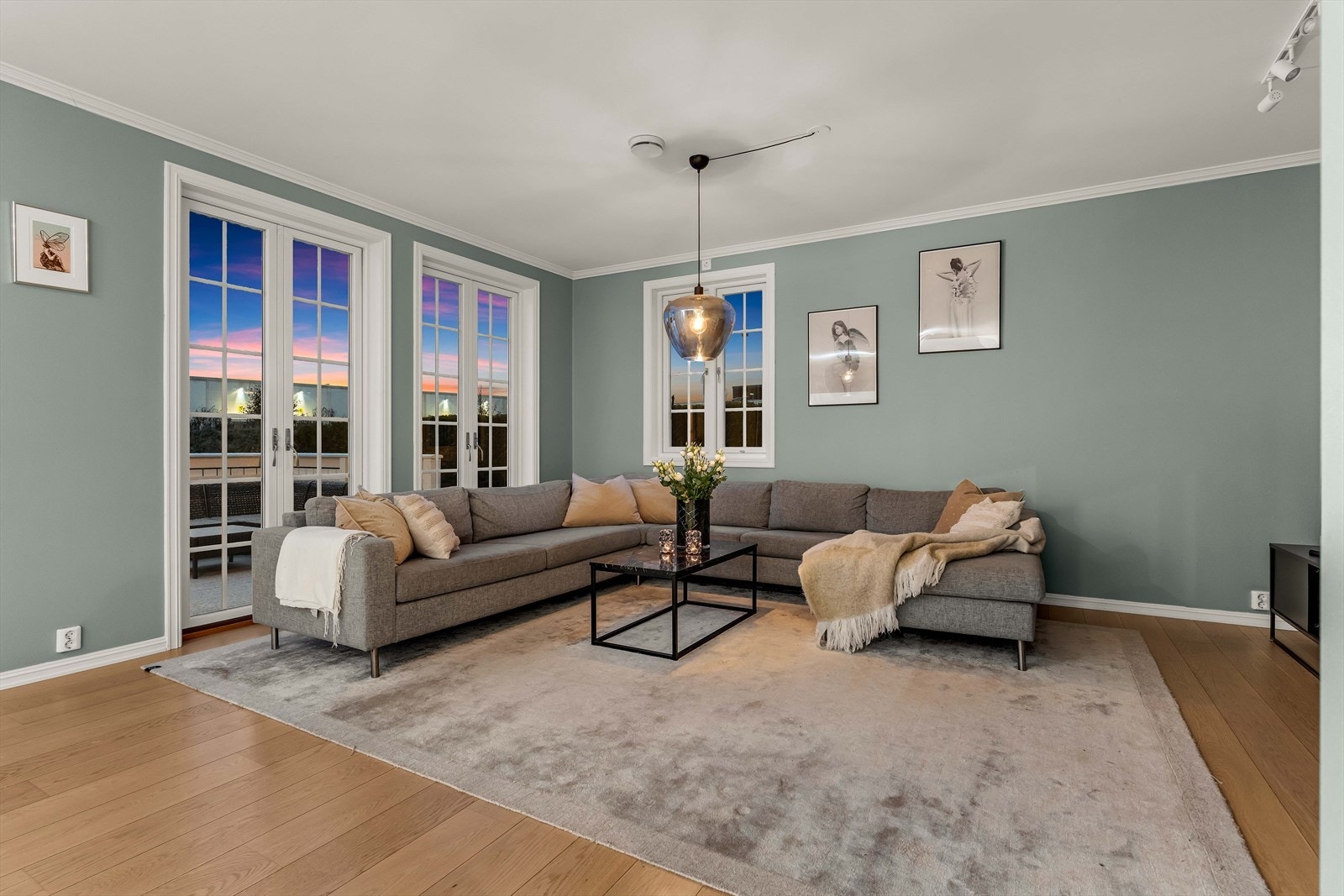 Utsikten mot terrassen, kombinert med det vakre landskapet på himmelen, skaper en avslappende og behagelig atmosfære i stuen på kveldstid. Galleribilde