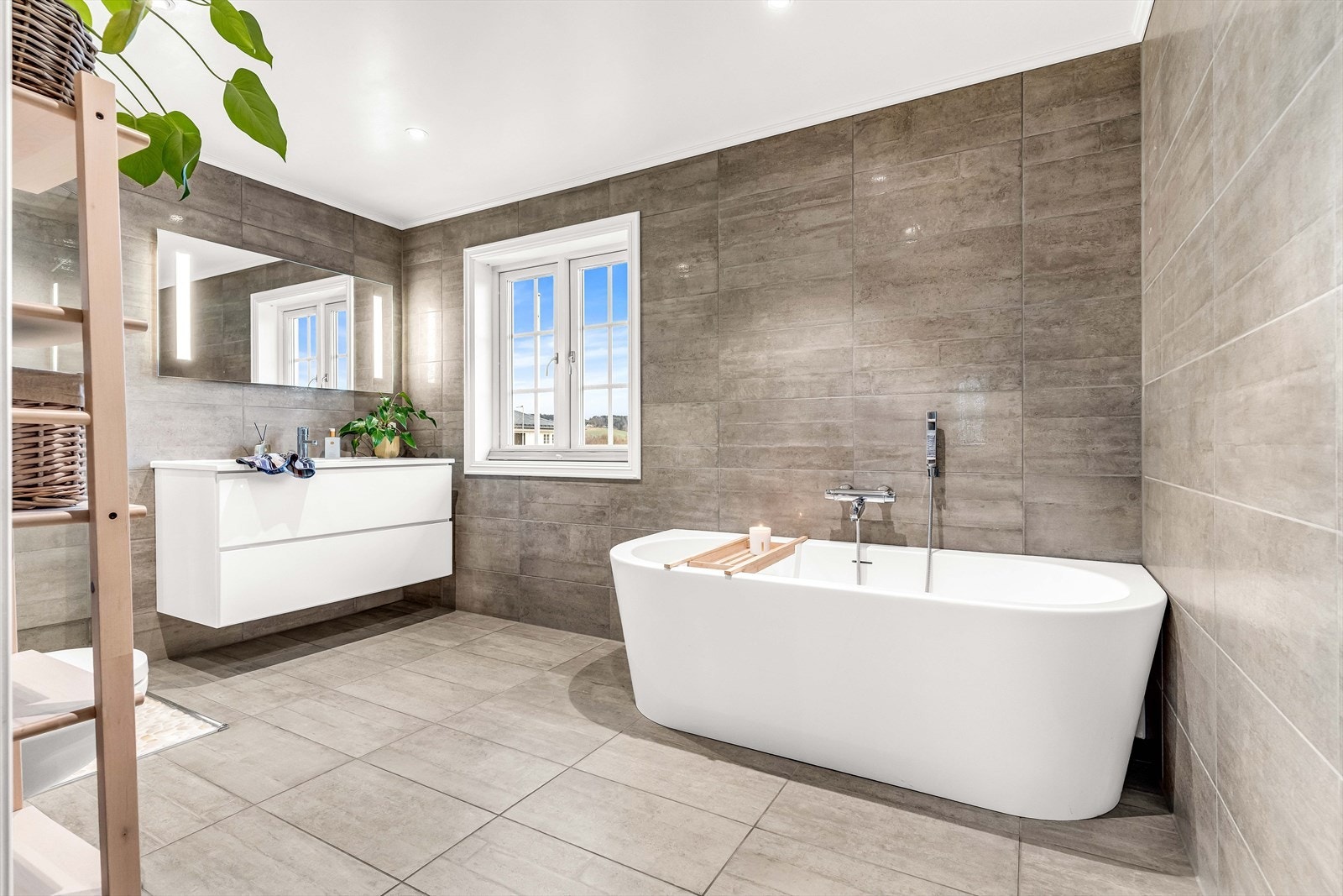 Badekaret står på flislagt gulv og gir en avslappende badeopplevelse. Et vindu ved siden av slipper inn naturlig lys, som skaper en lys og behagelig atmosfære. Varmekabler i gulvet. Galleribilde