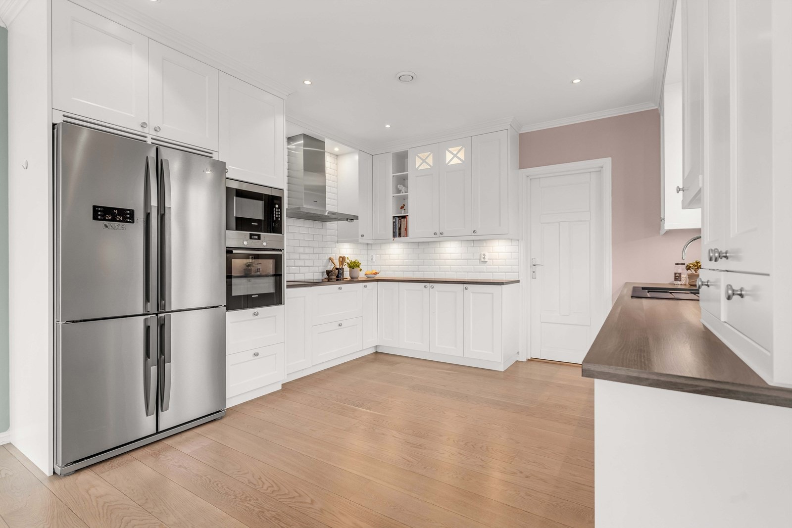 Hvite fronter kombinert med en laminatbenkeplate skaper et klassisk og tidløst kjøkken. Galleribilde