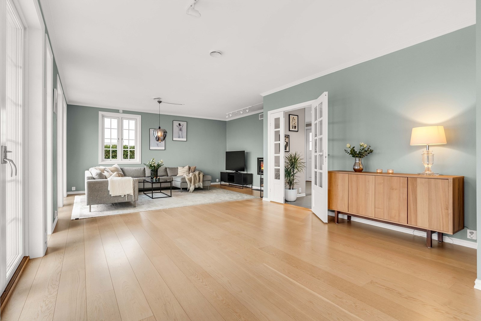 Åpen stue med elegant tregulv gir et romslig og innbydende oppholdsrom. Galleribilde