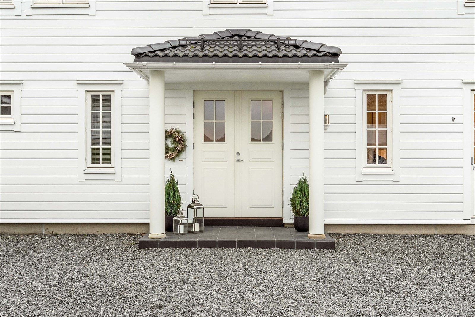 Pent inngangsparti med overbygg som gir en stilfull og innbydende ankomst til boligen. Galleribilde
