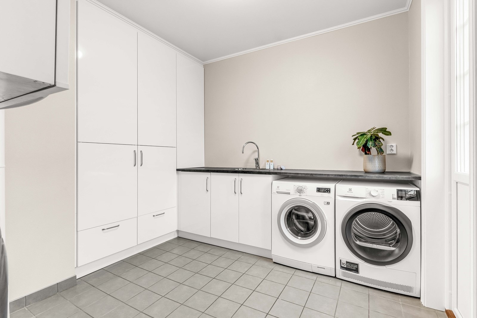 Vaskerommet har flislagt gulv og glatte fronter på innredningen, noe som gir en praktisk og lettstelt løsning. Rommet er utstyrt med opplegg for vaskemaskin og balansert ventilasjon i henhold til TEK17. Vaskerom med egen adkomst fra utsiden. Galleribilde