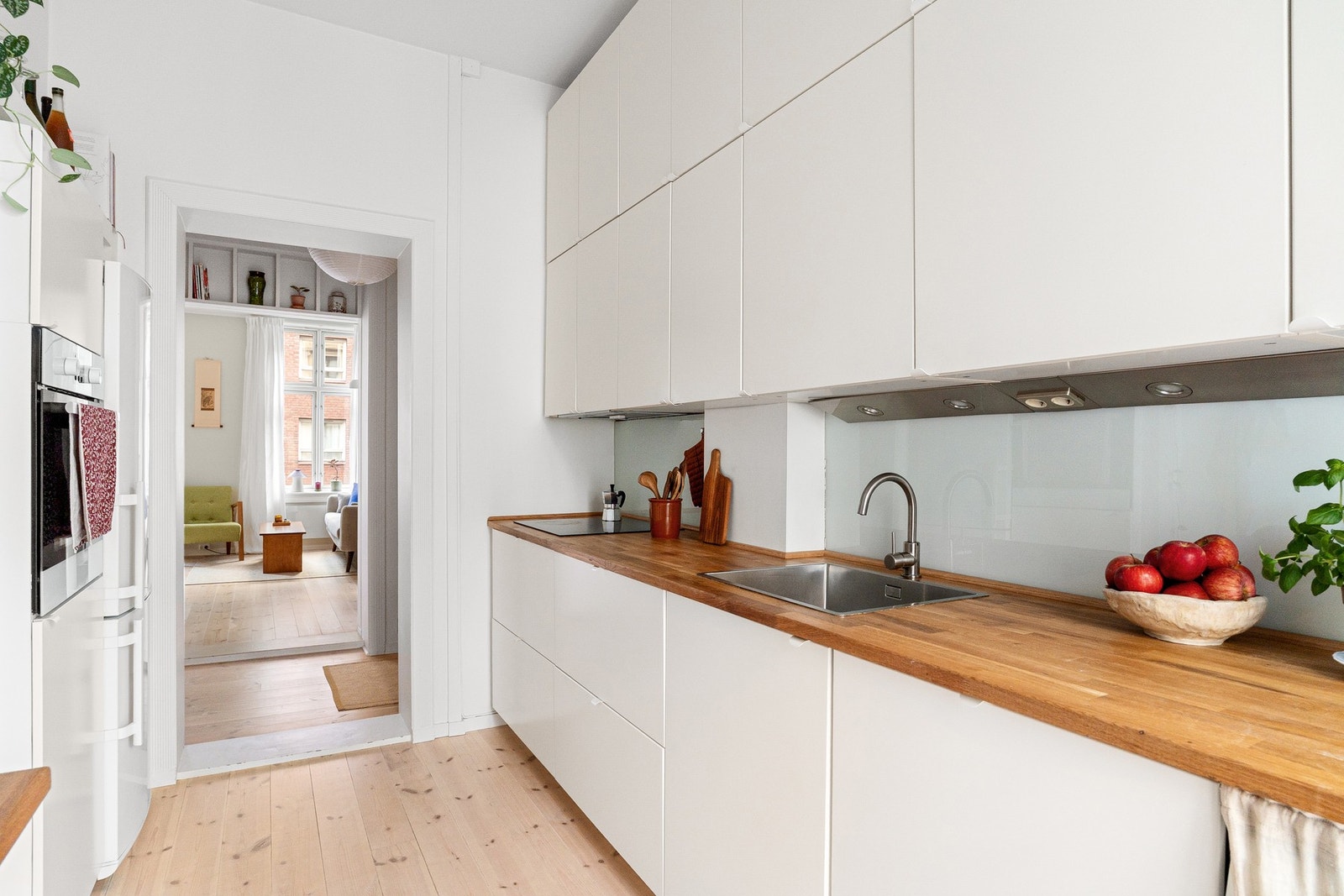 Lyst, flott kjøkken med rikelig skap- og benkeplass. Opplegg for vaskemaskin på kjøkkenet. Galleribilde