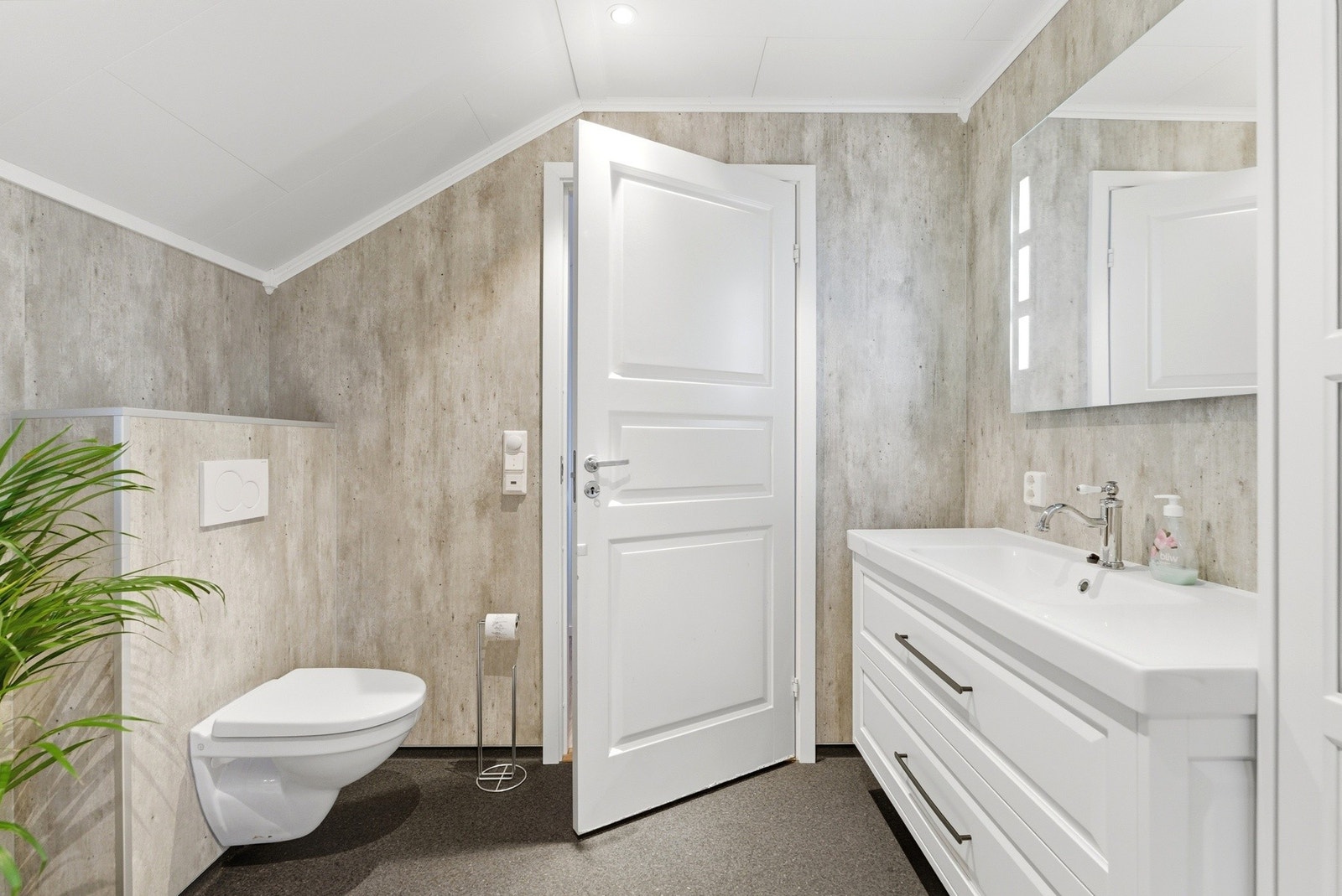 Utstyrt med vegghengt toalett, servant, badekar og dusjkabinett. Galleribilde