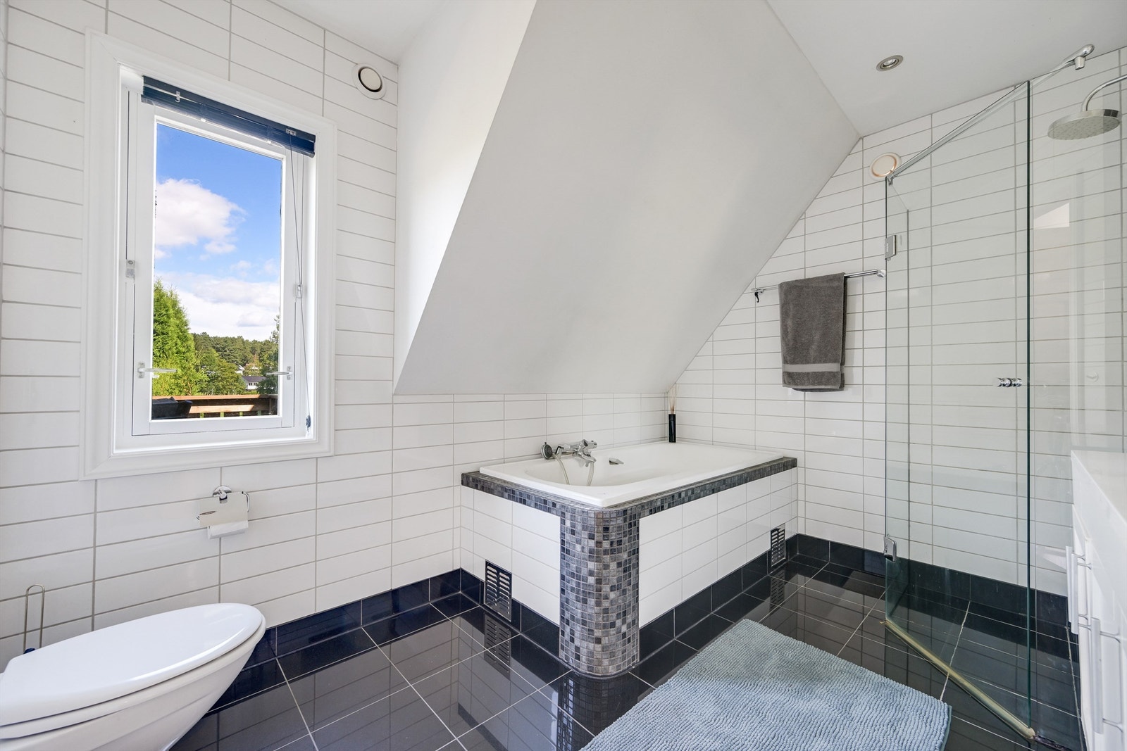 Lyst og romslig bad med flislagt gulv og vegger. Det er varmekabler i gulv med ny gulvtermostat og spotter i taket. Galleribilde