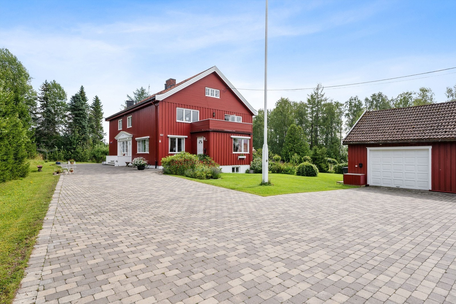 Eiendommen er pent opparbeidet med belegningsstein og beplantning. Galleribilde