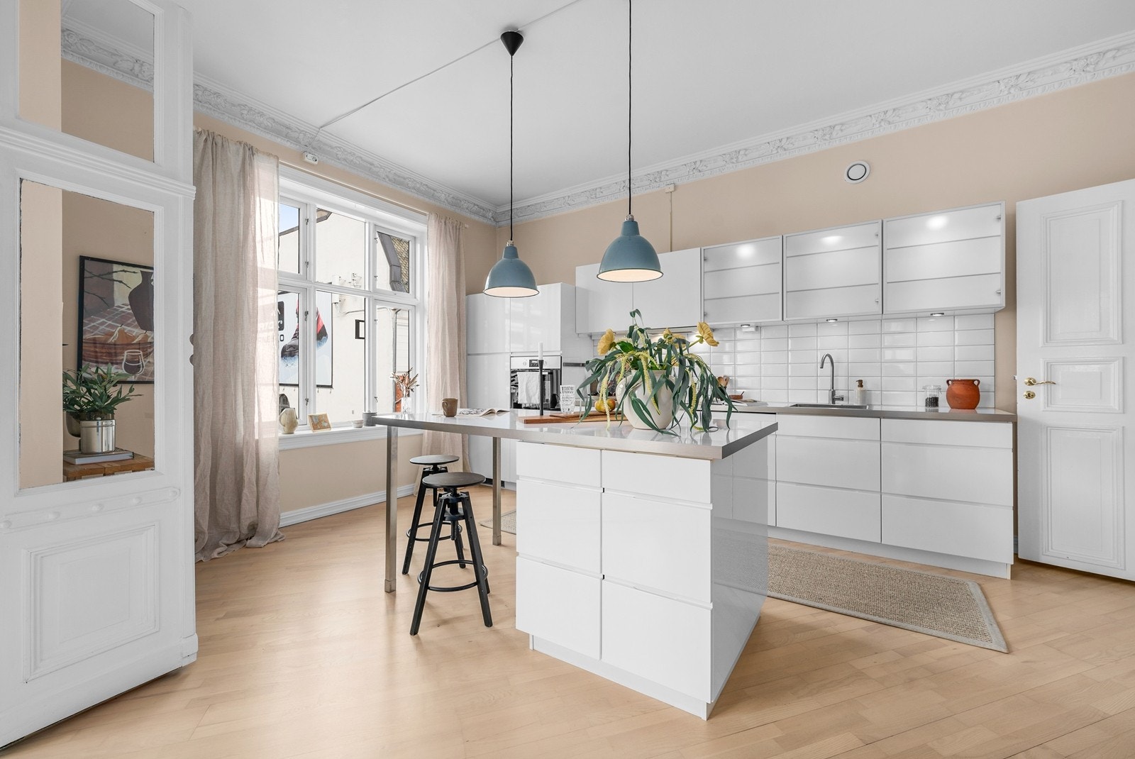 Glatte skapdører og skuffefronter. Enkelte overskap med glassfronter. Godt med skap- og benkeplass. Fliser mellom benk og overskap. Galleribilde