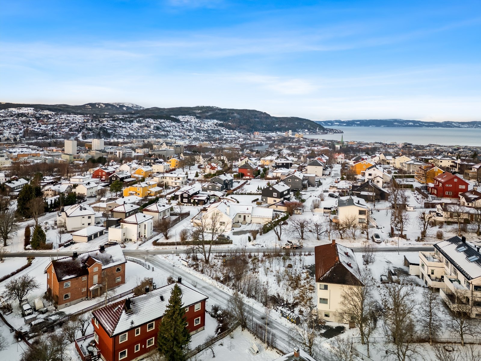 Tomten kan skilte med vid, flott utsikt utover nabolag og mot byen, med fjellene som pent bakgrunnsteppe. Galleribilde