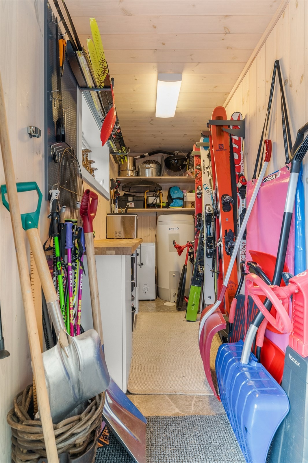 Tilgang til bod fra overbygd inngangsparti. Her med arbeidsbenk, ekstra fryser og tekniske installasjoner. Galleribilde