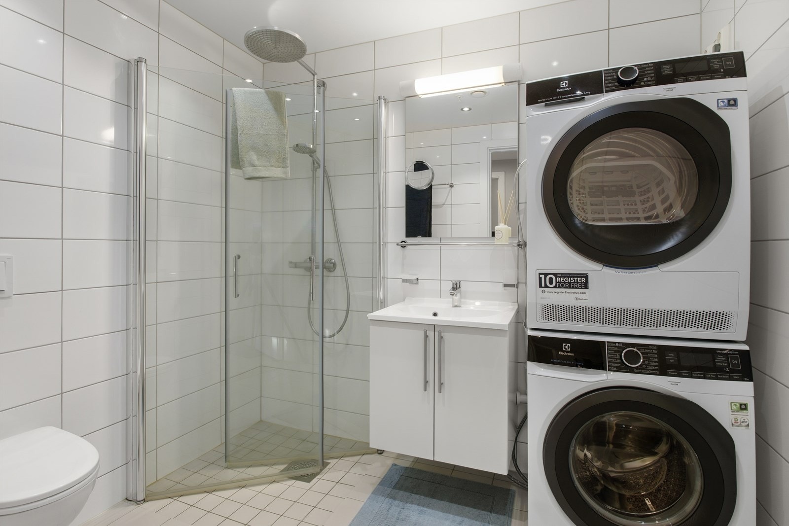 Baderommet, som nås fra entréen, er pent flislagt og har varmekabler i gulvet. Opplegg til vaskemaskin og tørketrommel. Galleribilde