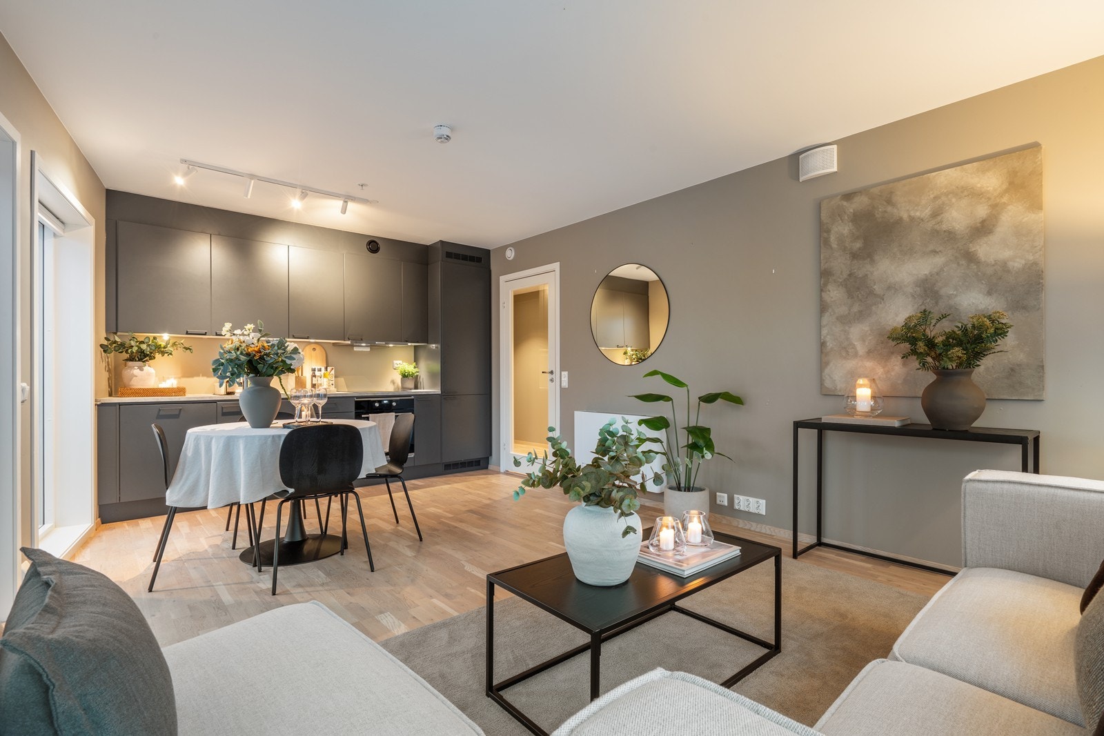 Stilrent kjøkken i åpen løsning mot stuen, hvor spisestuen fungerer som et naturlig bindeledd mellom sonene. Galleribilde