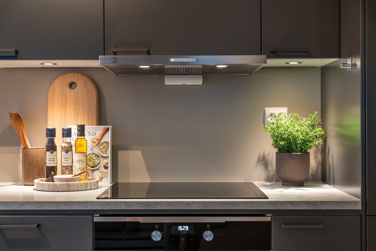 Innredningen har elegante, mørke detaljer, og spotter over kjøkkenbenken gir god belysning. Galleribilde