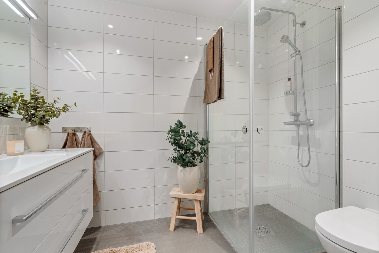 Dusjhjørnet er delikat utformet med mosaikkfliser på gulvet. Galleribilde