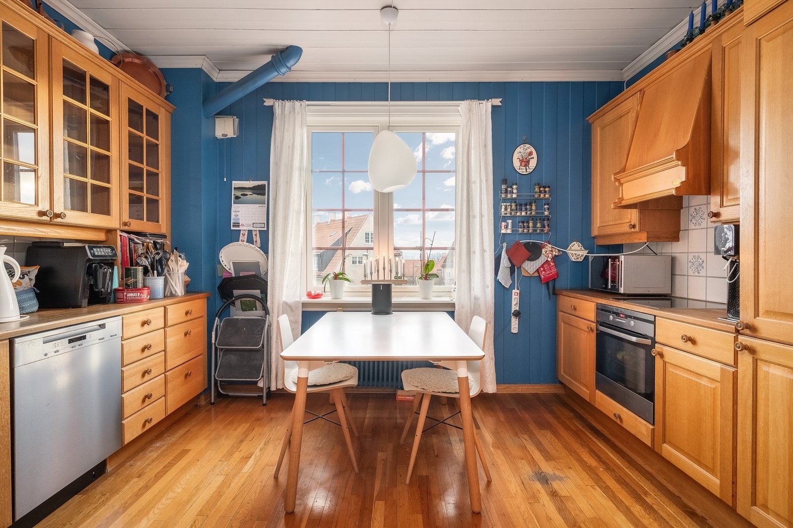 Eldre kjøkkeninnredning bestående av profilerte fronter av tre, benkeplate av tre og oppvaskkum av stål. Avtrekk ut av yttervegg Galleribilde