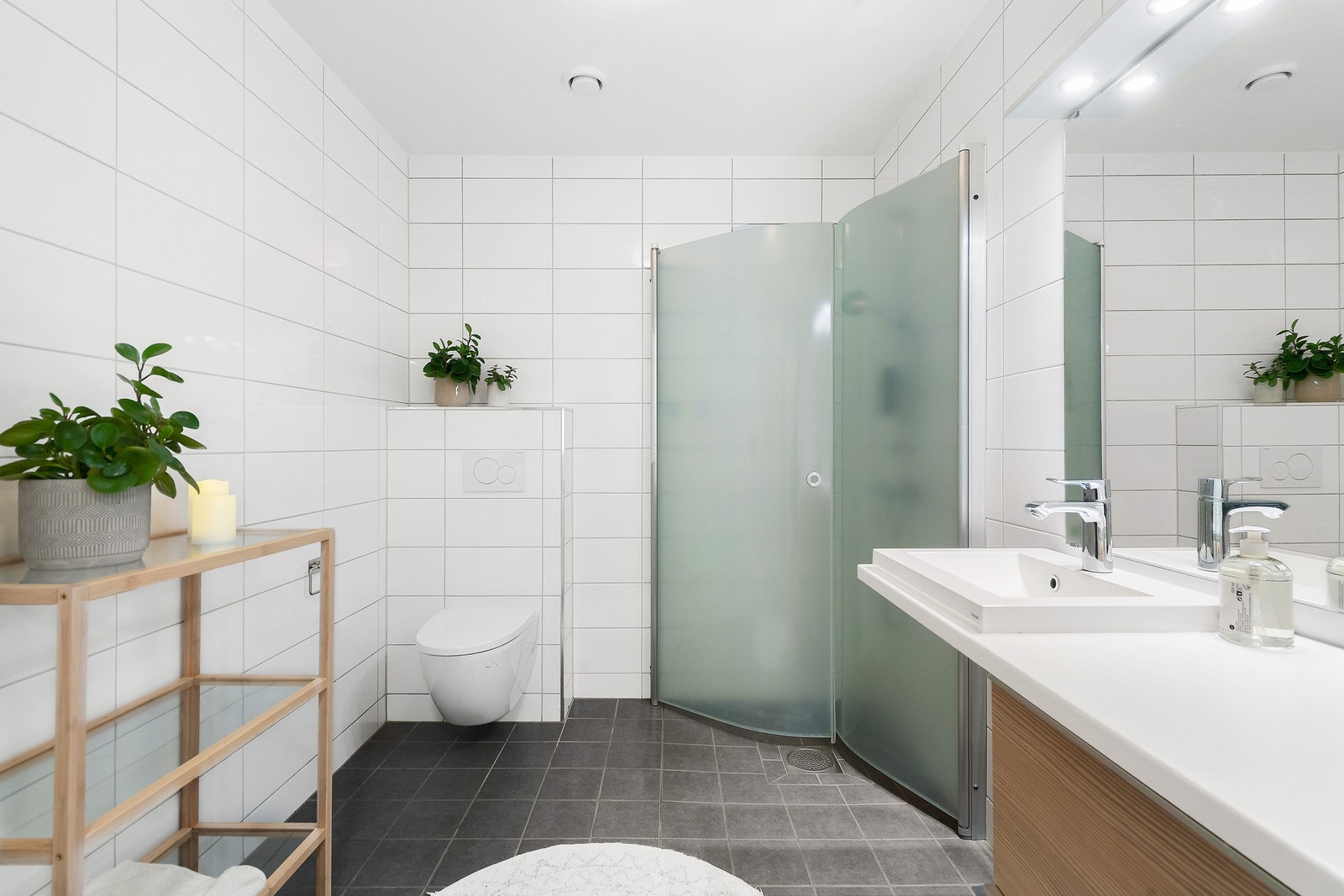 Romslig, flislagt bad med frostede dusjdører. Galleribilde