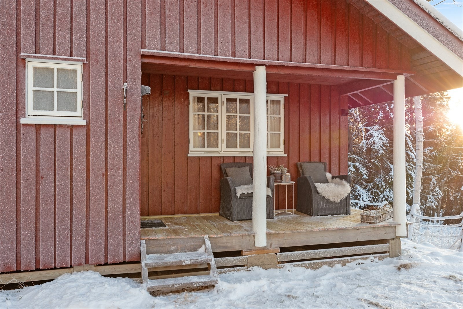 Overbygd veranda gir beskyttelse mot vær og vind, med utsikt mot snødekt skogområde. Galleribilde