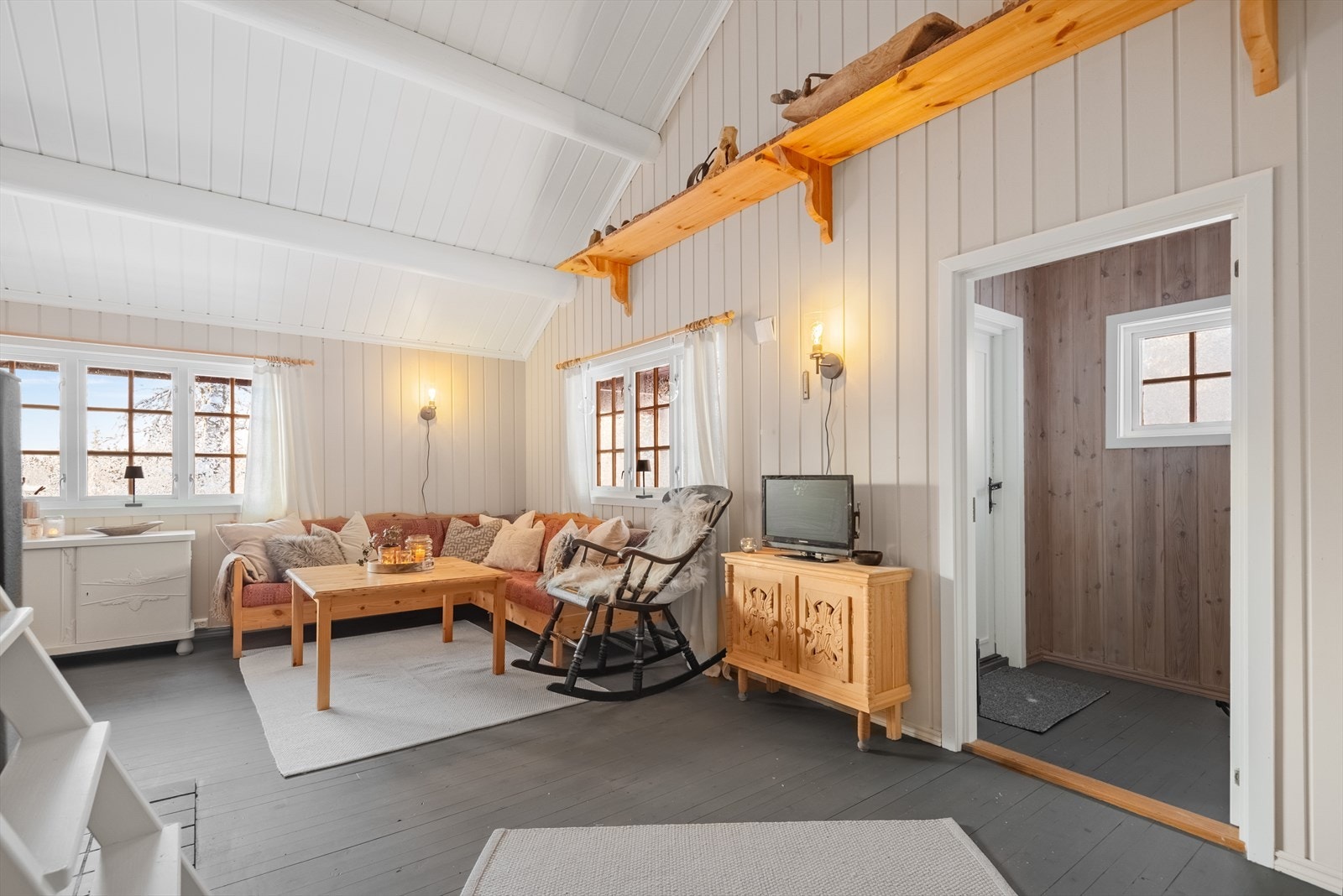 Panelte vegger og synlige bjelker gir en tradisjonell hyttestil. Galleribilde