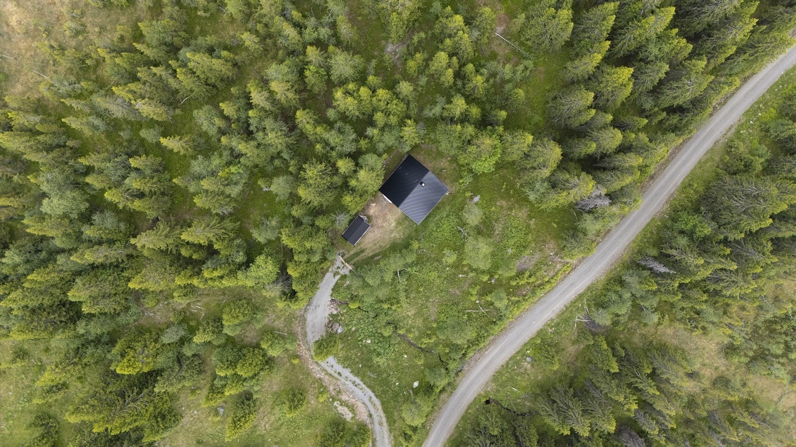 Eiendommen ligger omkranset av skog, med enkel adkomst via grusvei. Galleribilde