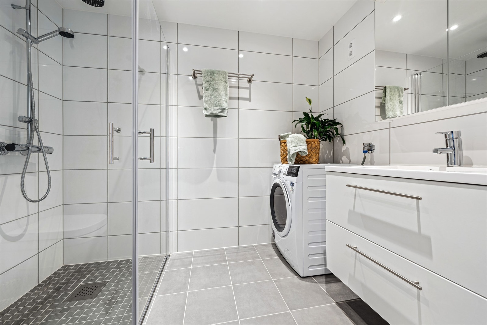 Flislagt bad med gulvvarme og opplegg for vaskemaskin/tørketrommel Galleribilde