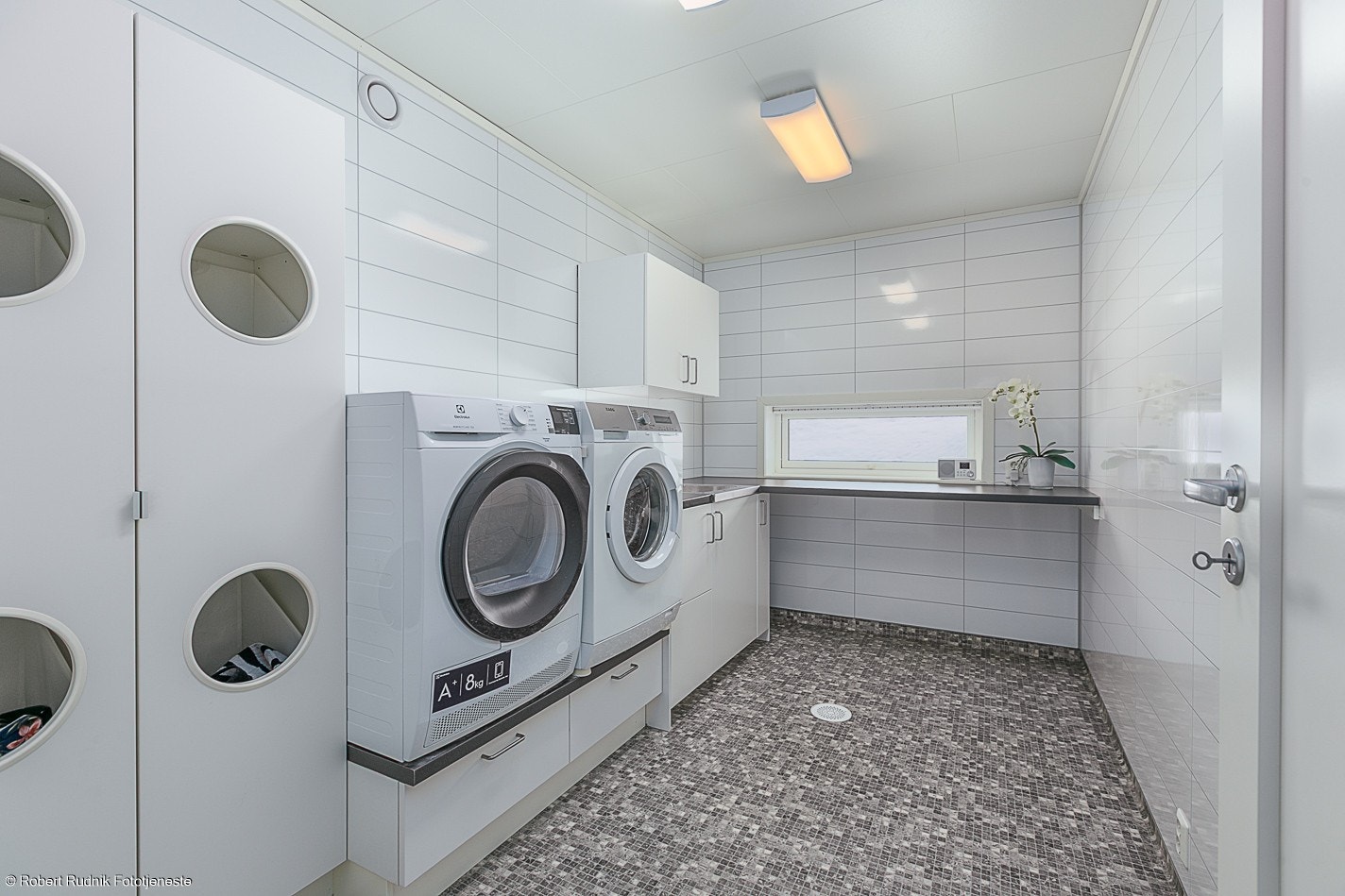 Eget vaskerom med opplegg for vaskemaskin og tørketrommel, godt med benkeplass og dyp utslagsvask. Galleribilde