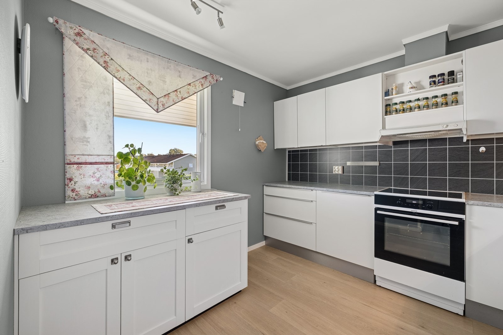 Kjøkkenet ligger praktisk plassert i et eget rom og det er rikelig med skap- og benkeplass. Kjøkkeninnredning ble fornyet i 2015 med hvite glatte fronter og laminat benkeplate med nedfelt kum i rustfritt stål. Galleribilde