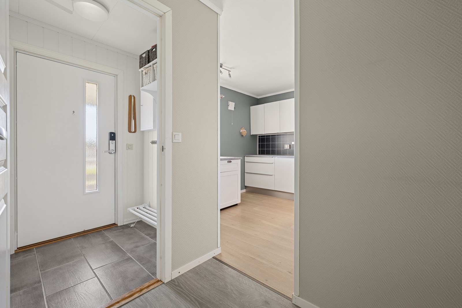 Her ønskes du velkommen inn i en flislagt entré med plass til å henge fra deg yttertøy. Galleribilde